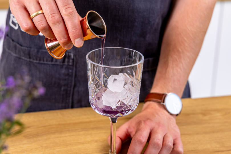 Lavendelsirup ins Glas geben