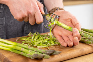 grünen Spargel im unteren Drittel schälen
