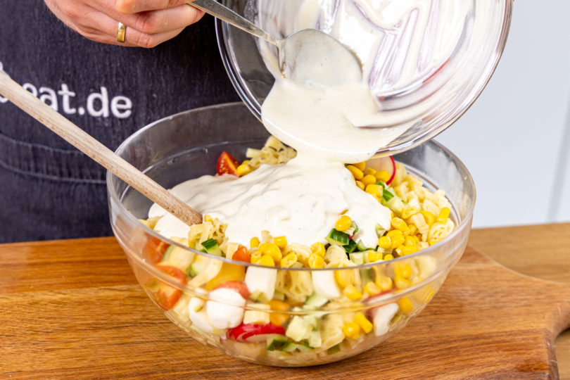 Dressing über Nudelsalat für Kinder geben