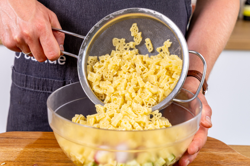 gekochte Nudeln in Salatschüssel geben