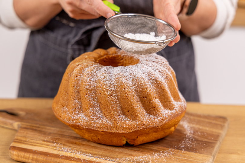 Guglhupf mit Puderzucker bestäuben