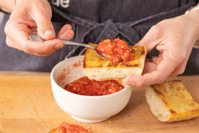 geröstetes Brot mit Tomatenpüree belegen