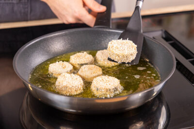 panierte Zucchinischeiben in der Pfanne braten
