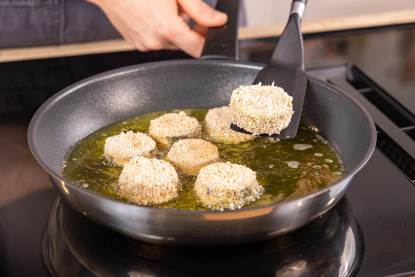 panierte Zucchinischeiben in der Pfanne braten