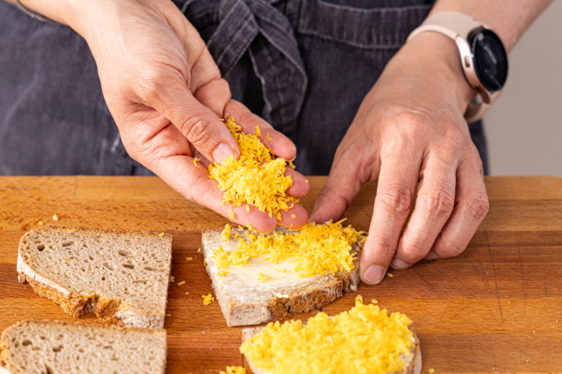 Brothälfte mit Butter uns Cheddar belegen