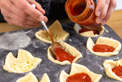 Sauce auf dem Teig verteilen