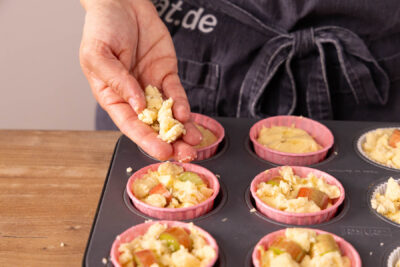Streusel auf Rhabarber Muffins verteilen