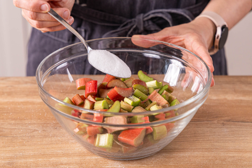 Zucker zu Rhabarberstücken geben