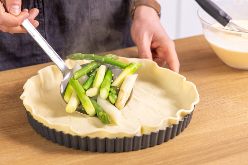 Spargel auf den Teig geben