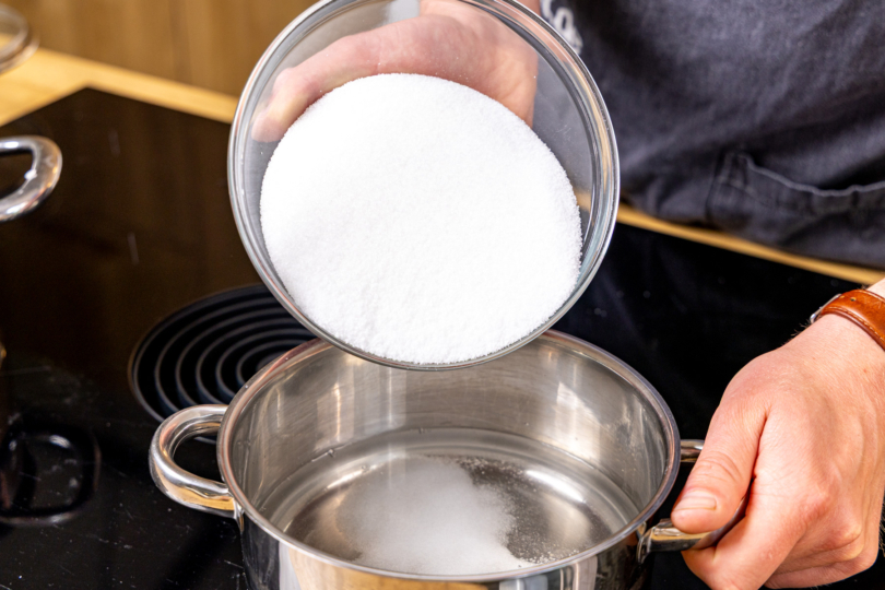 Zucker und Wasser in einen Topf geben