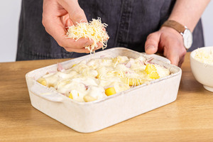 Spargelauflauf mit Schinken mit Käse bestreuen
