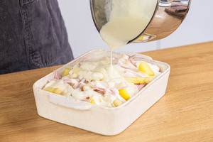 Sauce ünber den Spargelauflauf mit Schinken gießen