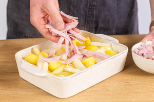 Schinkenstreifen zum Auflauf geben