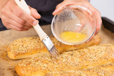 Fertige Baguettes mit Ei bestreichen