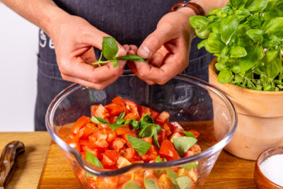 Basilikum über Tomatensalat mit Balsamico-Dressing zupfen