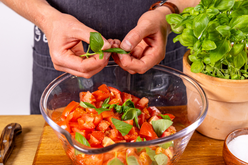 Basilikum über Tomatensalat mit Balsamico-Dressing zupfen
