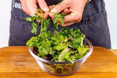 Blätter von der Petersilie zum Salat zupfen