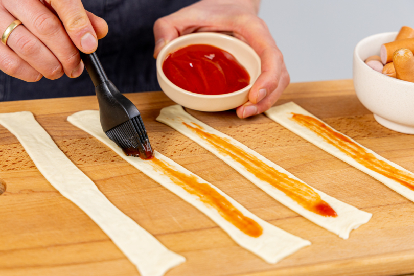 Teigstreifen mit Ketchup bestreichen