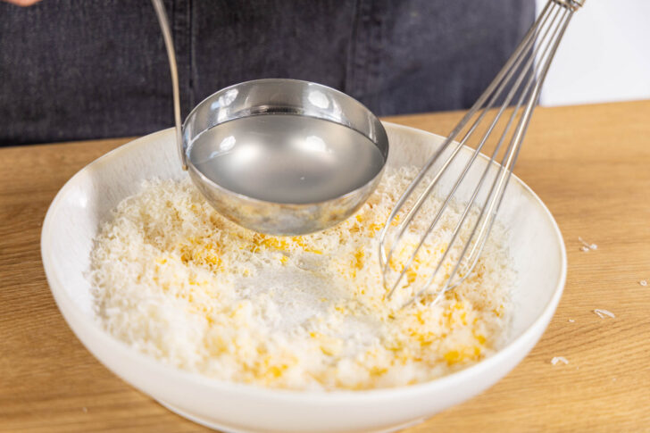 Pastawasser zu Parmesan und Ei geben