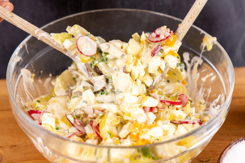 Eiersalat mit Kartoffeln vermengen
