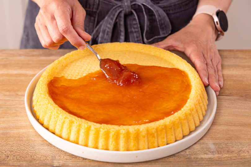 Erdbeerboden mit Marmeladen bestreichen