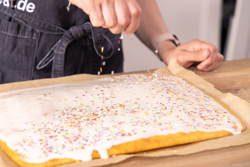 Fantakuchen mit bunten Streuseln dekorieren