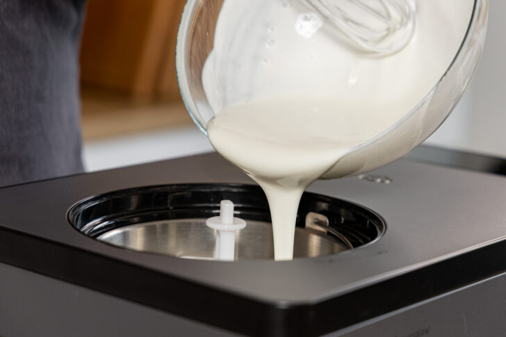 Joghurt-Masse in die Eismaschine gießen