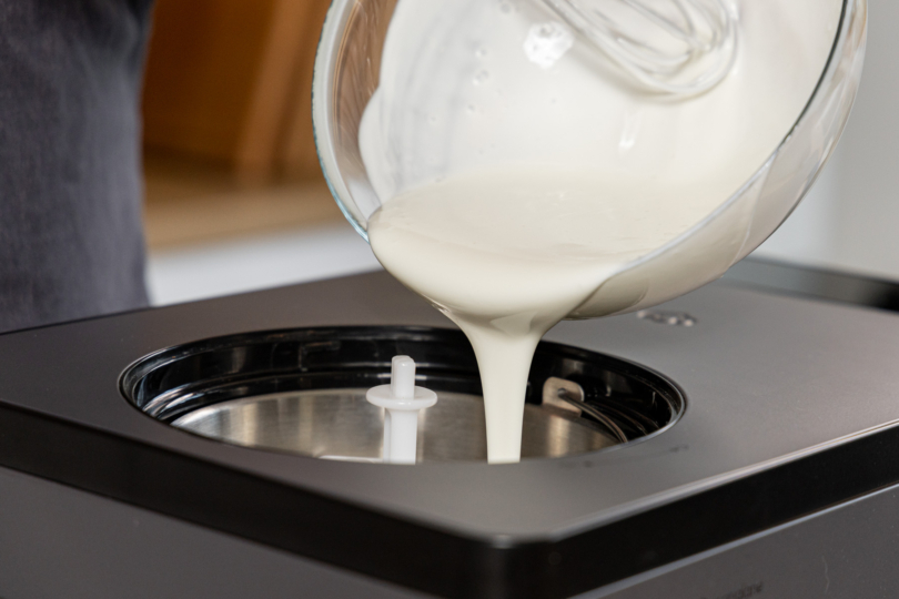 Joghurt-Masse in die Eismaschine gießen