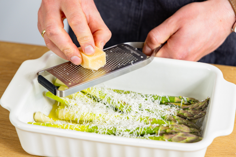Grana Padano über Spargel reiben