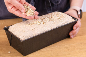 Haferflockenbrot mit Haferflocken bestreuen