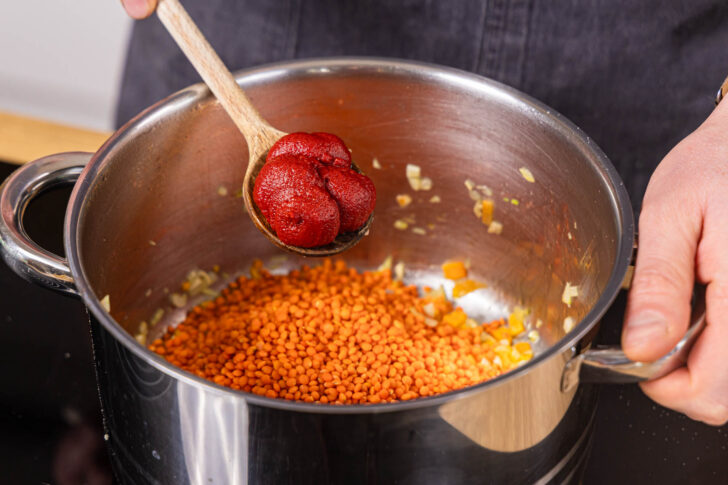 Tomatenmark zu den Linsen geben