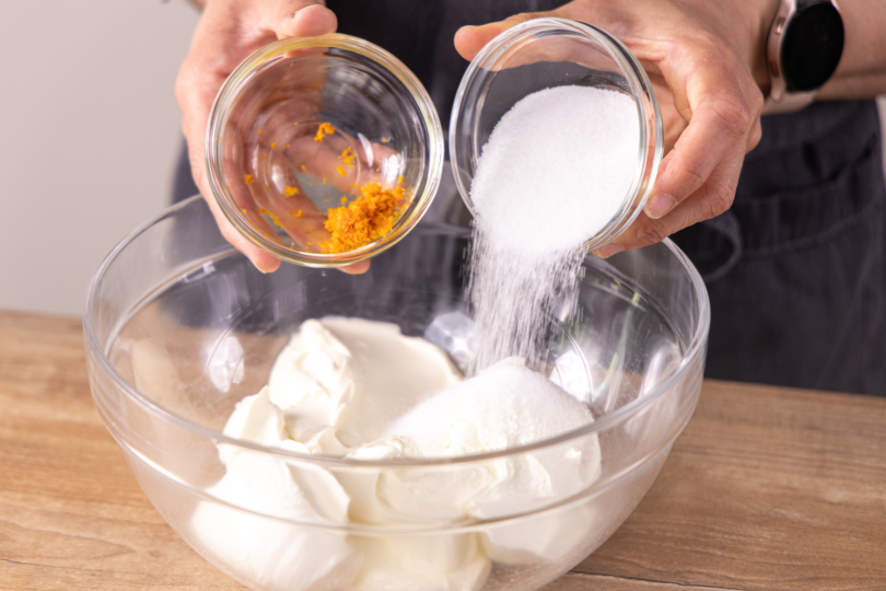 Zucker und Orangenschale dazugeben