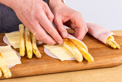 gebratenen Spargel mit Käse und Schinken einrollen