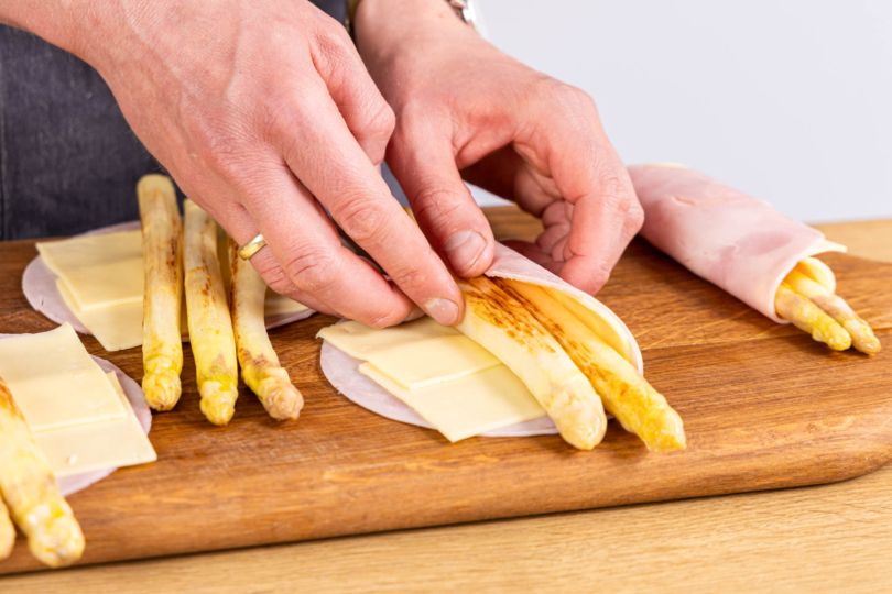 gebratenen Spargel mit Käse und Schinken einrollen