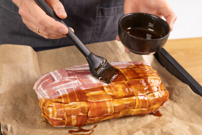 Bacon Bomb mit BBQ Sauce bepinseln