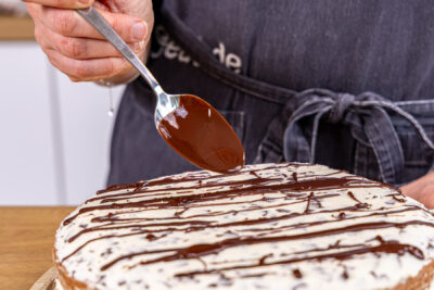 Bananensplit Torte mit geschmolzener Schokolade dekorieren