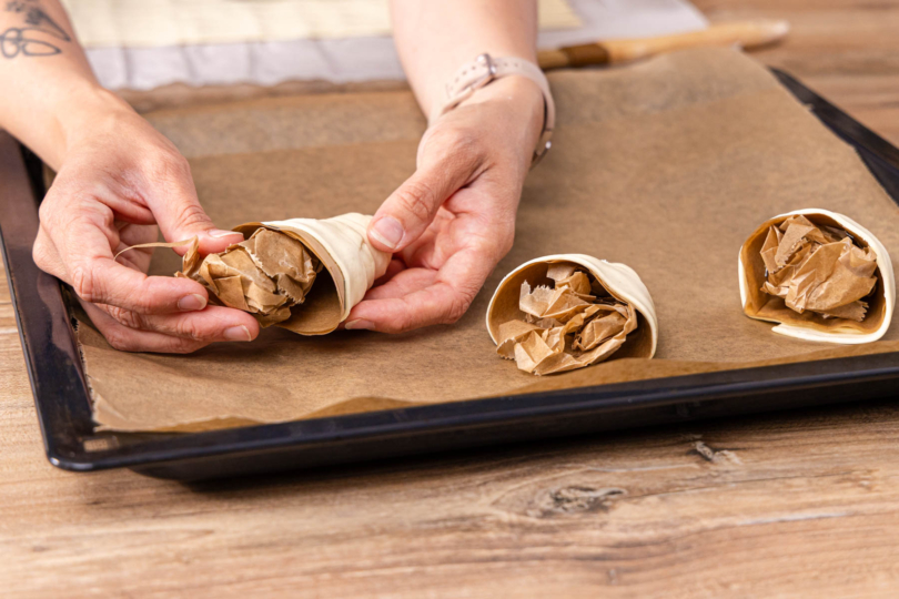 Blätterteigkegel mit Backpapier ausstopfen