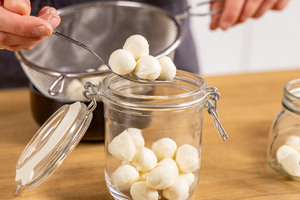 Mini-Mozzarellakugeln in ein Glas geben