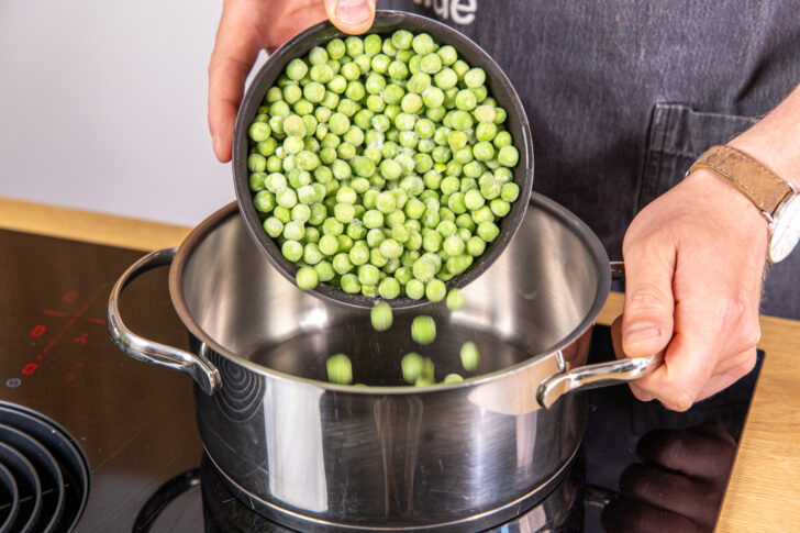 Erbsen in einen Topf geben