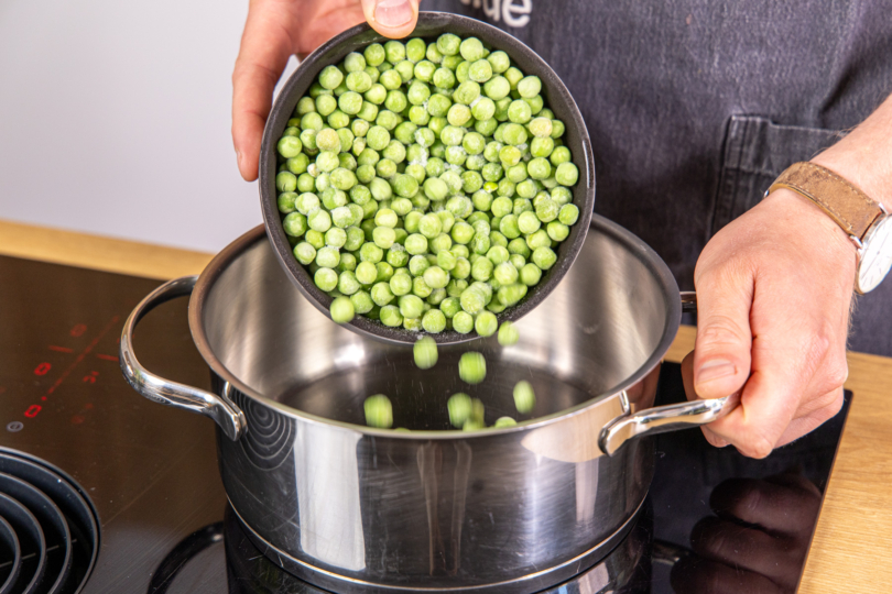 Erbsen in einen Topf geben