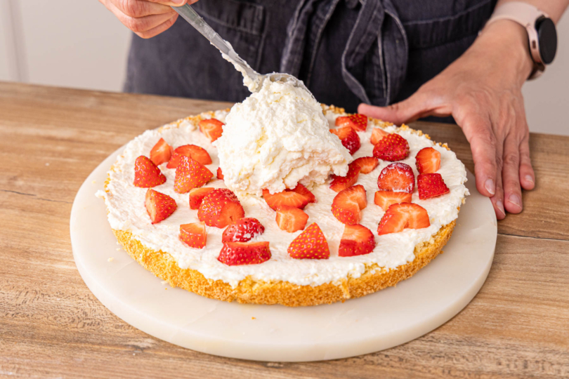 Creme auf die Erdbeeren geben