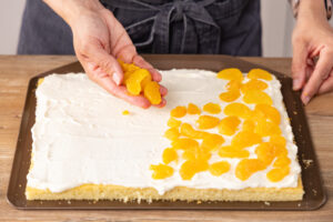 Mandarinen auf der Creme verteilen