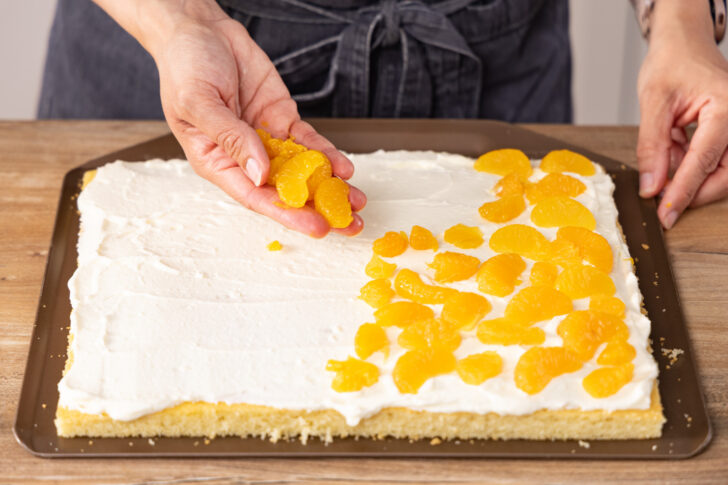Mandarinen auf der Creme verteilen