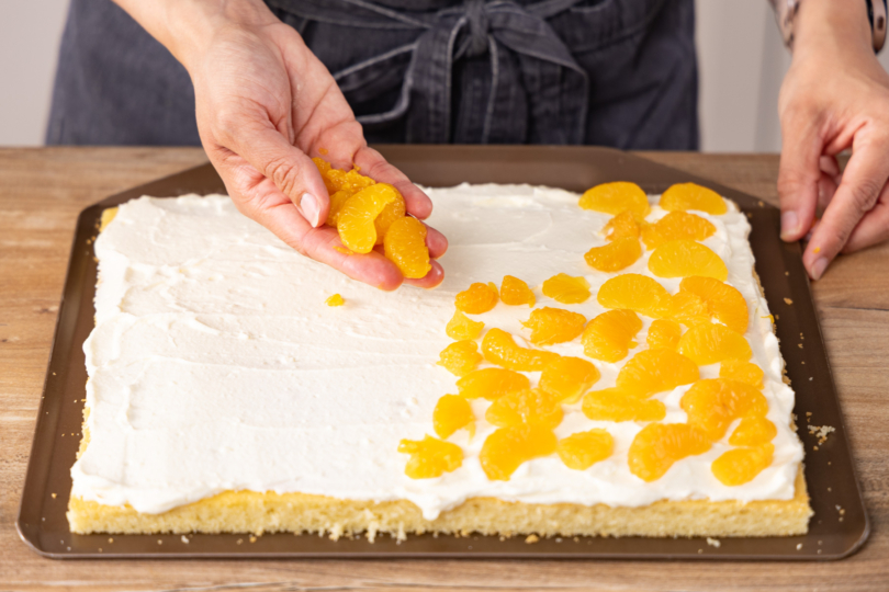 Mandarinen auf der Creme verteilen