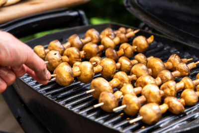 Champignon-Spieße auf den Grill legen