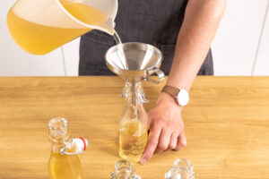 Holunderblütensirup in Flaschen abfüllen