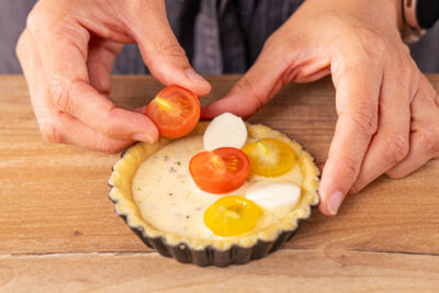 Tomaten und Mozzarella in die MAsse legen und Tomaten Tartelettes backen