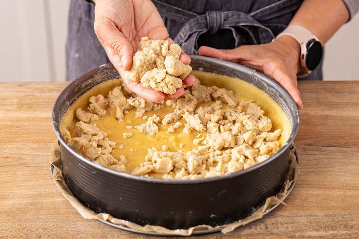 Streusel auf dem Kuchen verteilen