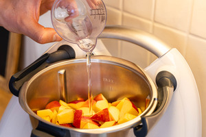 Wasser zu den Apfelstücken gießen