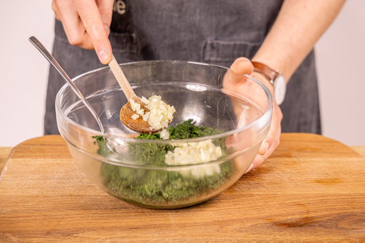 Zwiebel und Knoblauch zum Spinat geben